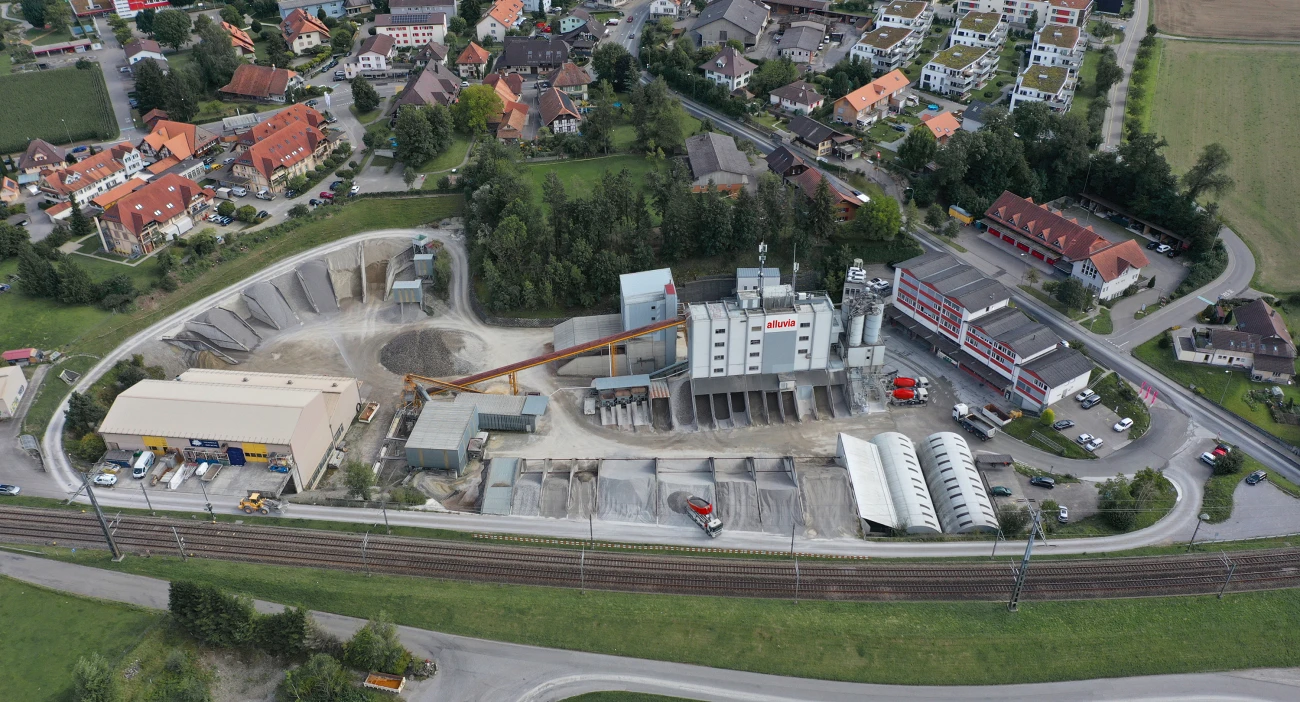 Drohnenansicht vom Kies- und Betonwerk Hindelbank mit dem Bürogebäude und einem Teil des Dorfes Hindelbank im Hintergrund.
