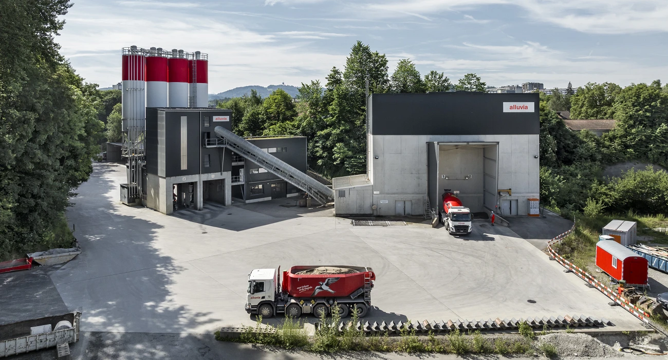 Betonwerk Bern-Bethlehem. Graue Betonzentrale und Kiessilos und rot-weisse Zementsilos.